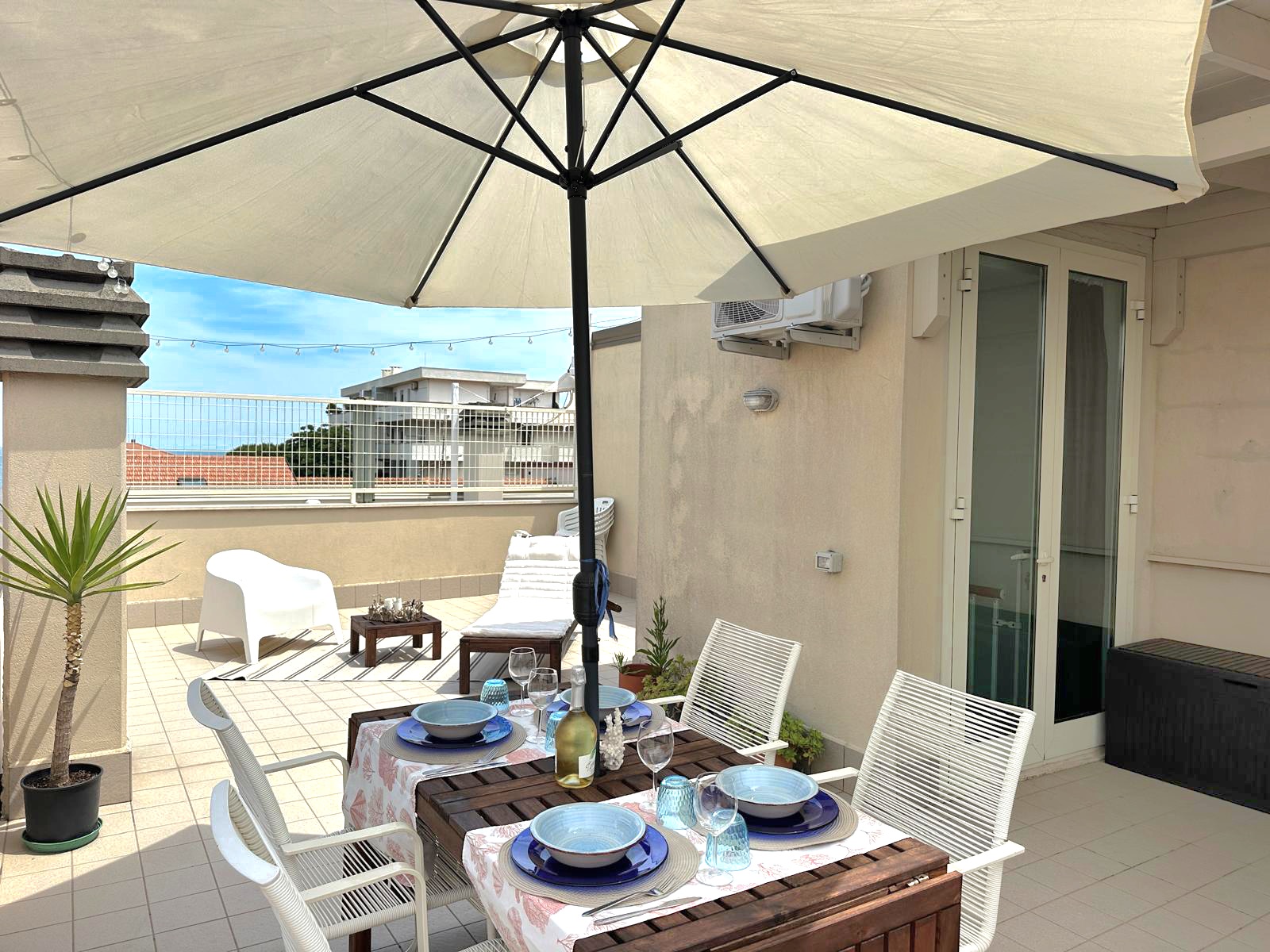 Tavolo esterno sotto ombrellone sulla terrazza
